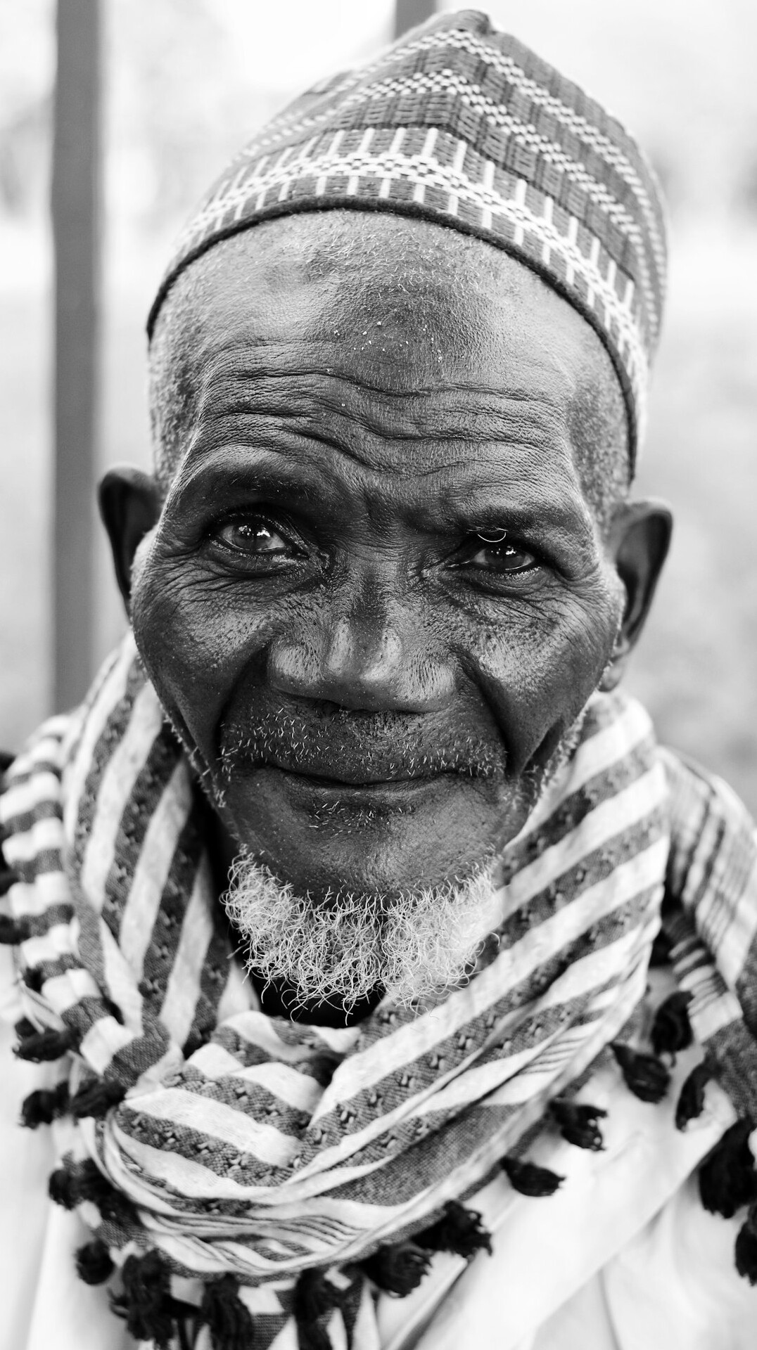 Elderly Canadian man with a warm smile sitting by a window