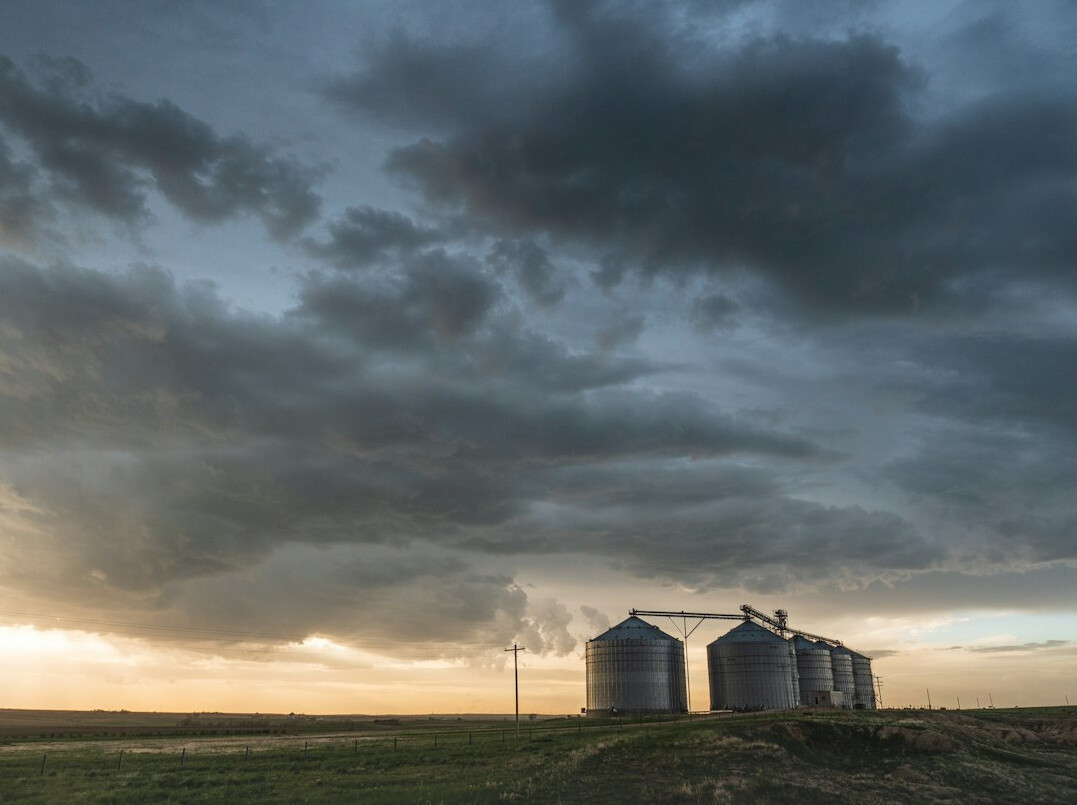 Prairie farmland with a grain silo under a wide sky